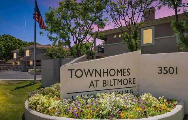 a sign for the townhomes at biltmore in front of a flag