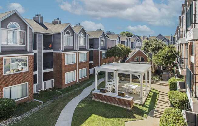 A sunny day at a residential complex with apartment buildings and a central courtyard.