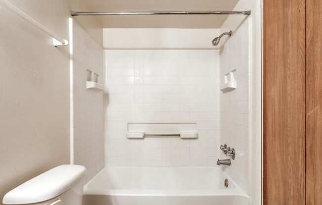 a bathroom with a toilet and a tub and a sink