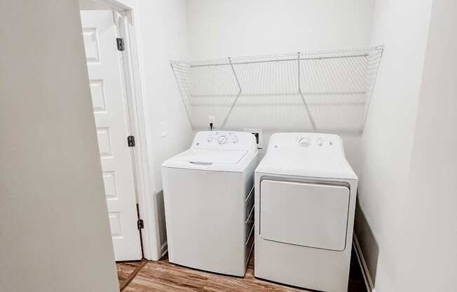 A laundry room with two washing machines and a clothes dryer.