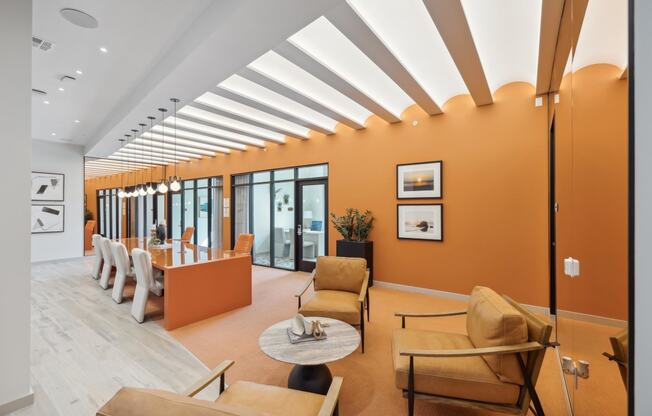 a living room with orange walls and chairs and a table