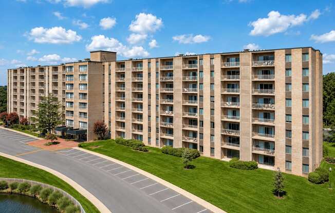A large apartment building with a parking lot in front.