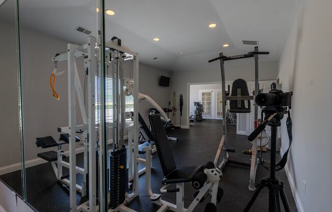 a gym with weights equipment and mirrors in a home
