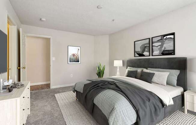 A bedroom with a large bed and a nightstand with a lamp.