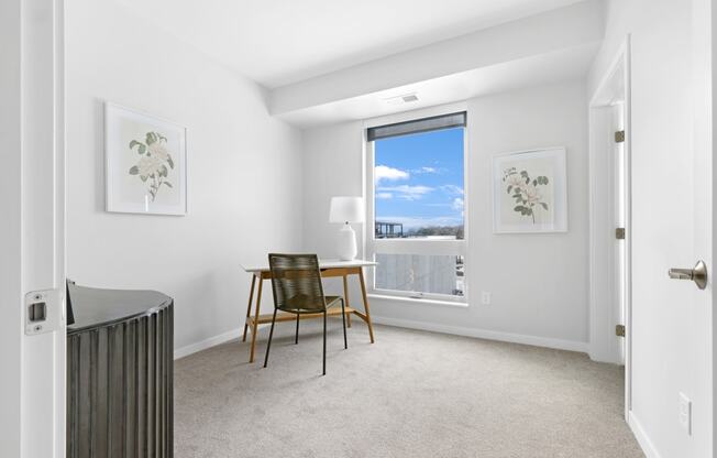 a bedroom with a desk and a window