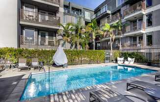 a swimming pool in an apartment building with palm trees