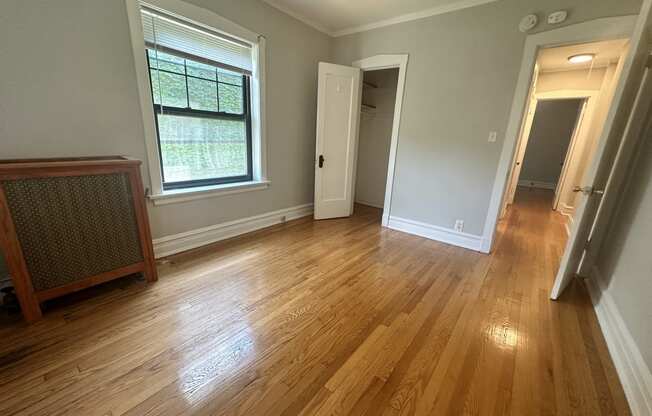 a living room with a hard wood floor and a large window