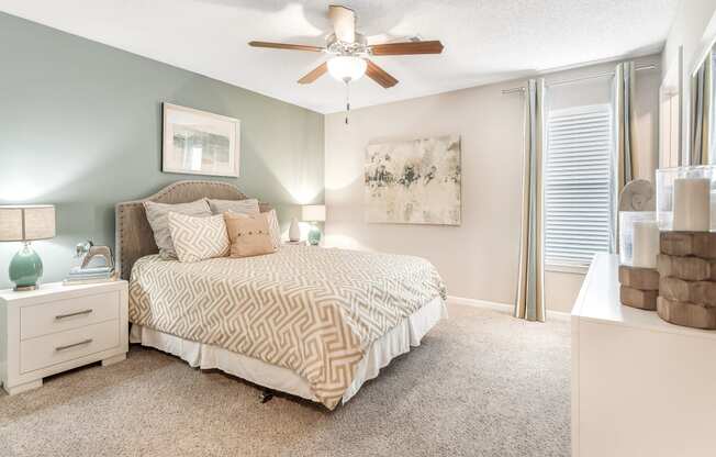 a bedroom with a bed and a ceiling fan at Avalon Apartments Starkville, MS