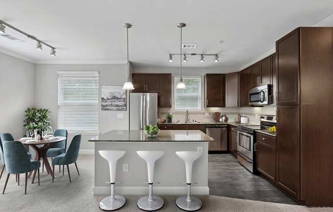 A kitchen with a table and chairs in front of it.