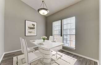 A dining room with a white table and chairs.