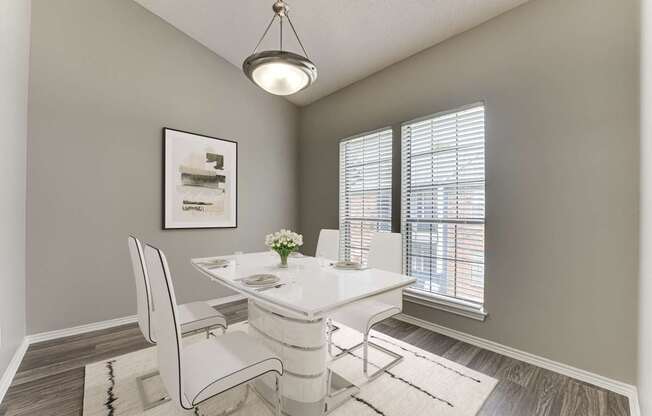 A dining room with a white table and chairs.