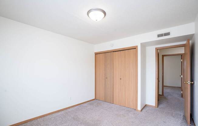 A room with a carpeted floor and a white ceiling with a light fixture. West Fargo, ND Sheyenne Terrace Townhomes