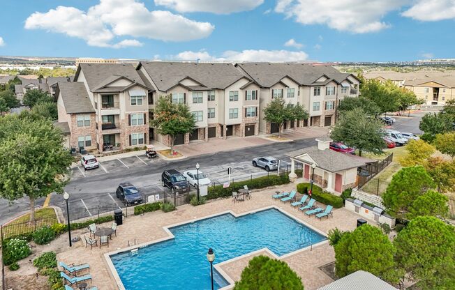 A large apartment complex with a pool in the foreground.