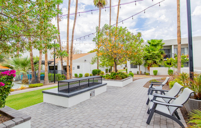 a patio with chairs and a fire pit