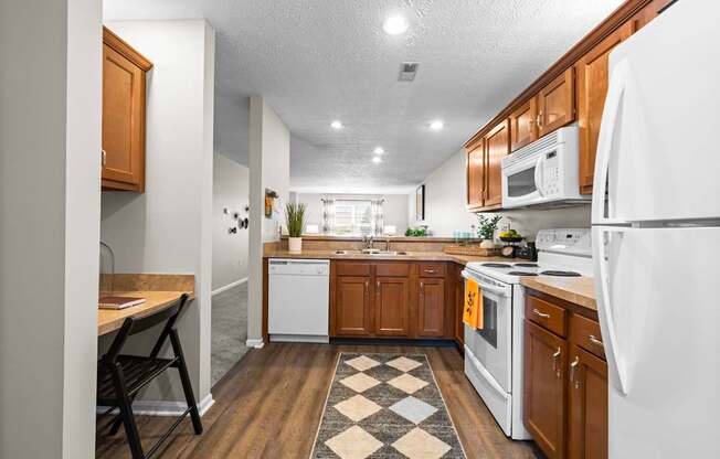 A kitchen with white appliances and wooden cabinets.