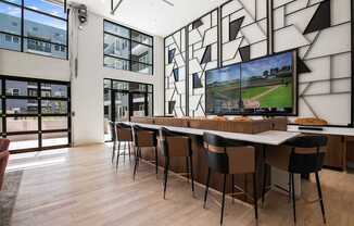 A modern room with a long table and chairs, a television, and a large window.