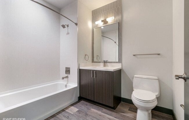 a bathroom with a toilet and a sink and a bath tub