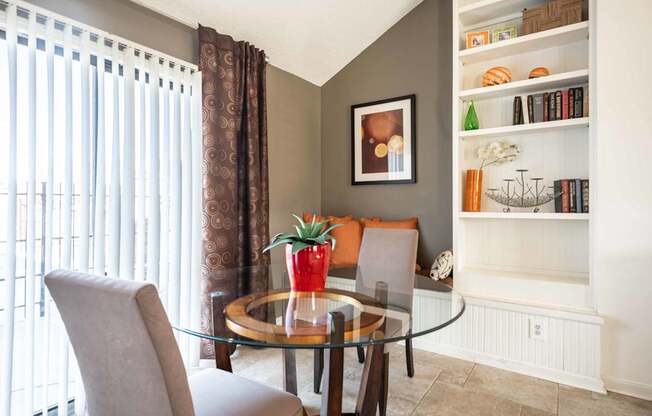 A dining room with a glass table and chairs.