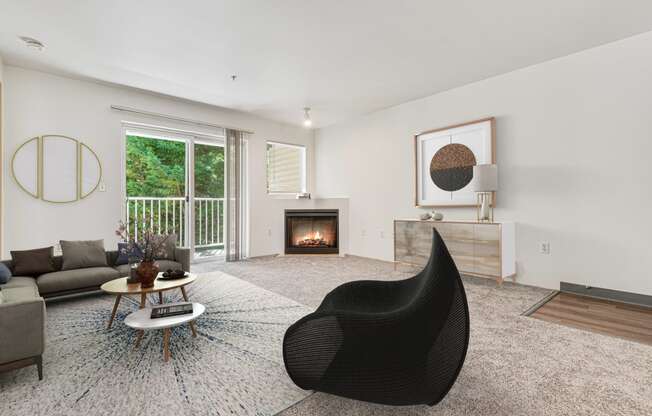 a living room with a black chair and a fireplace