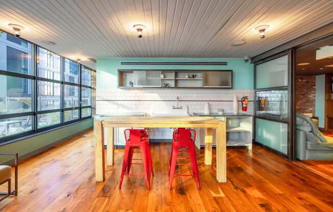 a kitchen with a wooden table and red chairs