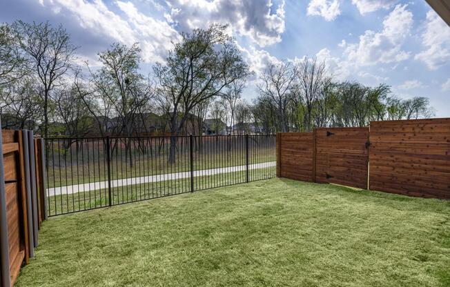 Private fenced backyard with grass perfect for pets.
