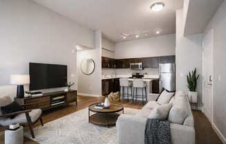 A modern living room with a grey couch and a wooden coffee table.