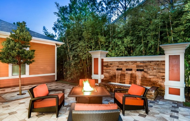 a backyard patio with a fire pit and chairs