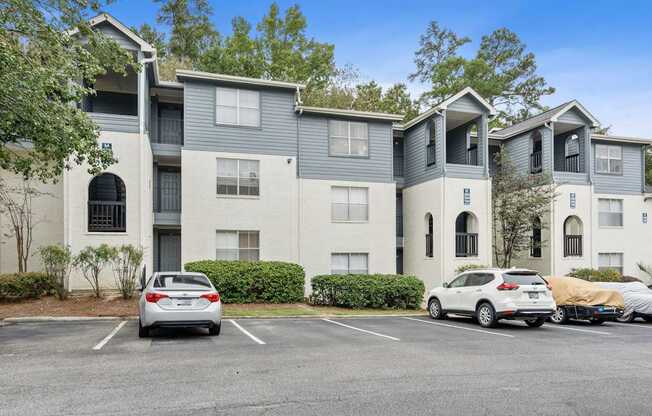 an apartment building with cars parked in front of it