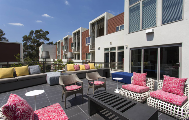 a seating area with couches and chairs in front of a building