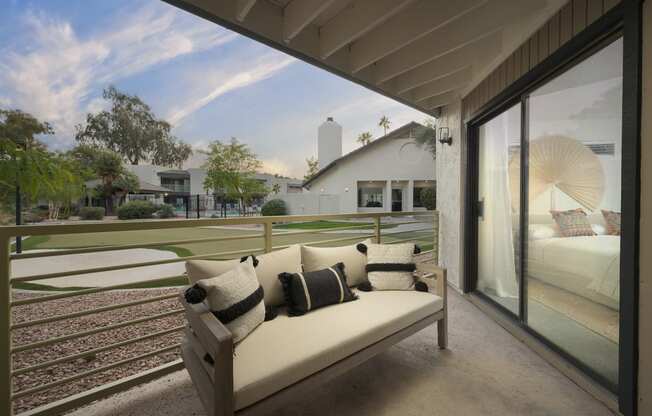 a sofa on a balcony with a view of a golf course