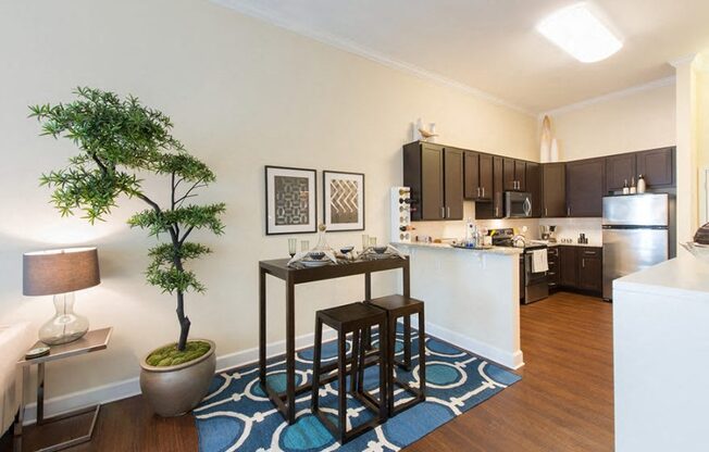 A kitchen with a table and chairs in the middle of a rug.