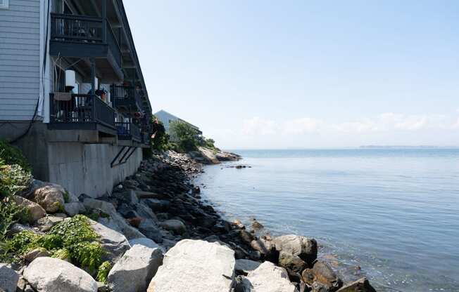 apartments on the edge of a cliff overlooking a body of water