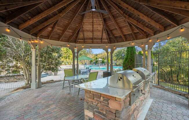 a patio with a barbecue grill and a pool