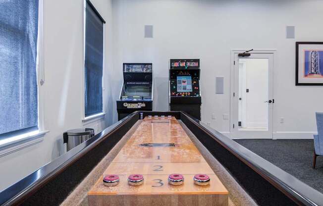 A bowling alley with a wooden lane and a pinsetter.