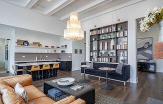 a living room with a kitchen and a couch and chairs