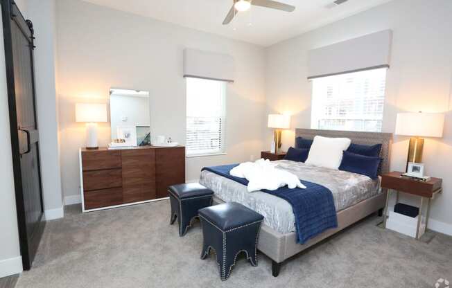 a bedroom with a bed and two night stands and a ceiling fan at Century Baxter Avenue, Louisville, KY