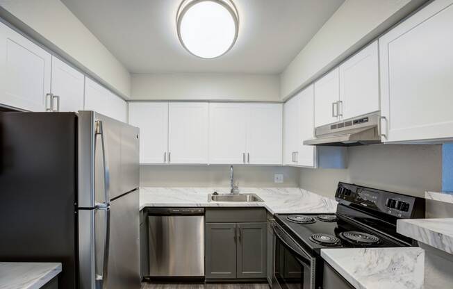 a kitchen with white cabinets and stainless steel appliances and a sink