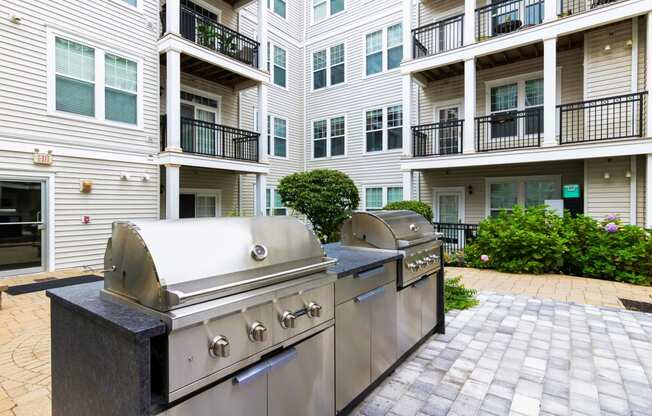 two grills in front of an apartment building at Metro 303, Hempstead New York