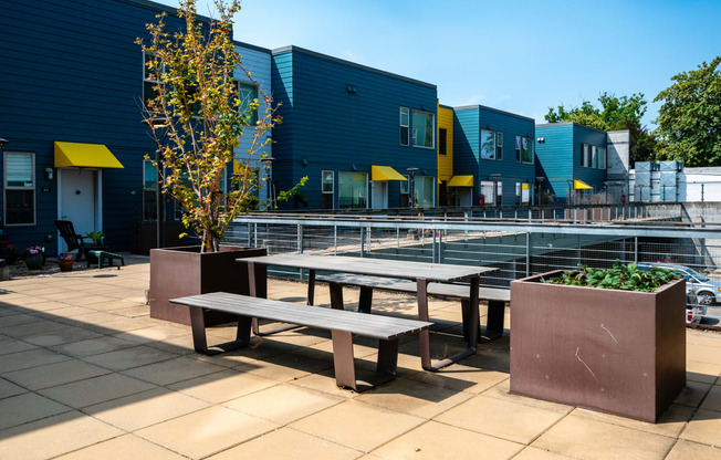 a communal seating area with benches and a tennis court