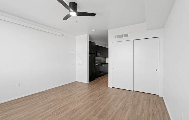 A room with a ceiling fan and a white cabinet.