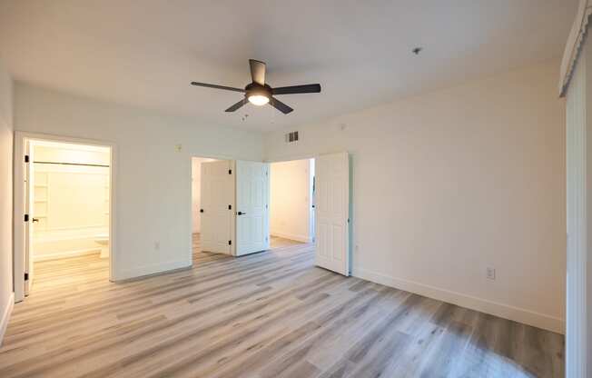 a bedroom with hardwood floors and a ceiling fan
