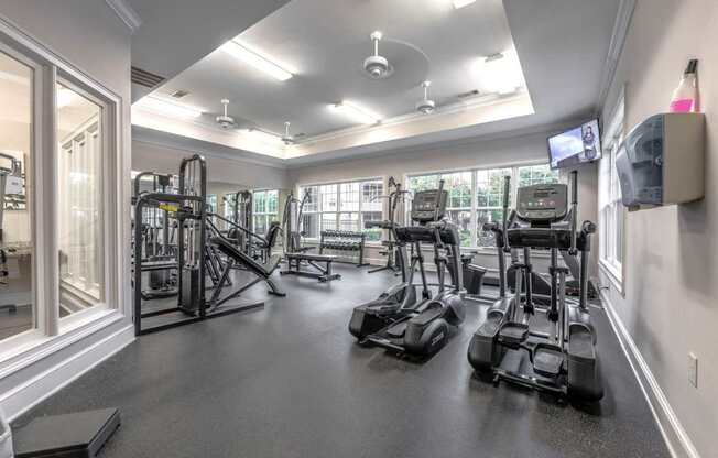 A spacious gym with a variety of equipment including treadmills, elliptical machines, and weight machines.