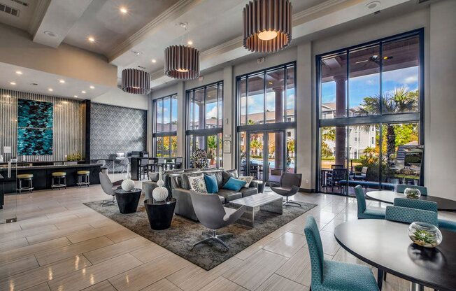 a lobby with chairs and tables and large windows at Volare at the Woodlands, The Woodlands, Texas