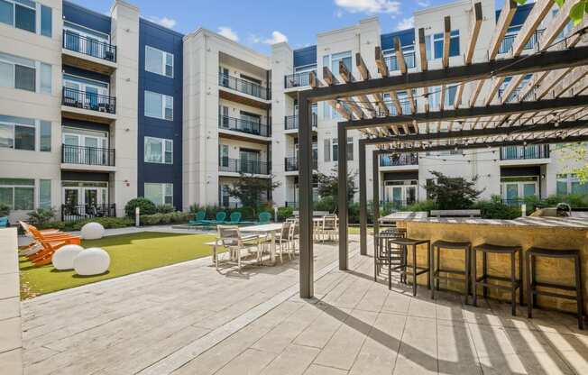 an outdoor patio with tables and chairs at the bradley braddock road station apartments