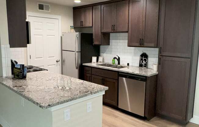 a kitchen with stainless steel appliances and granite counter tops