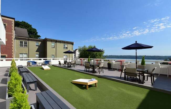 A patio area with a table and chairs overlooking a body of water.