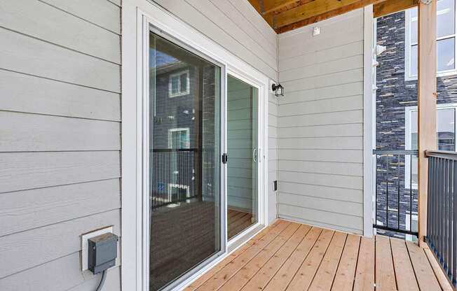 A balcony with a glass door leading to a patio.