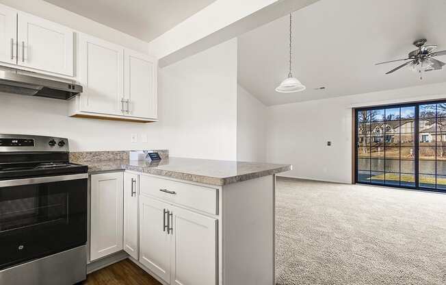 A kitchen with white cabinets and a breakfast bar at Tanglewood Apartments, Oak Creek, WI