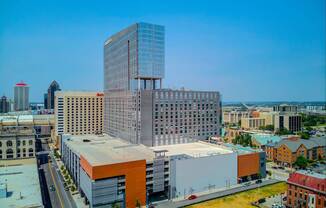 A modern glass building stands out in a cityscape.