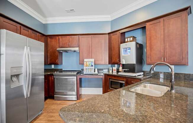 A kitchen with a granite counter top and stainless steel appliances.